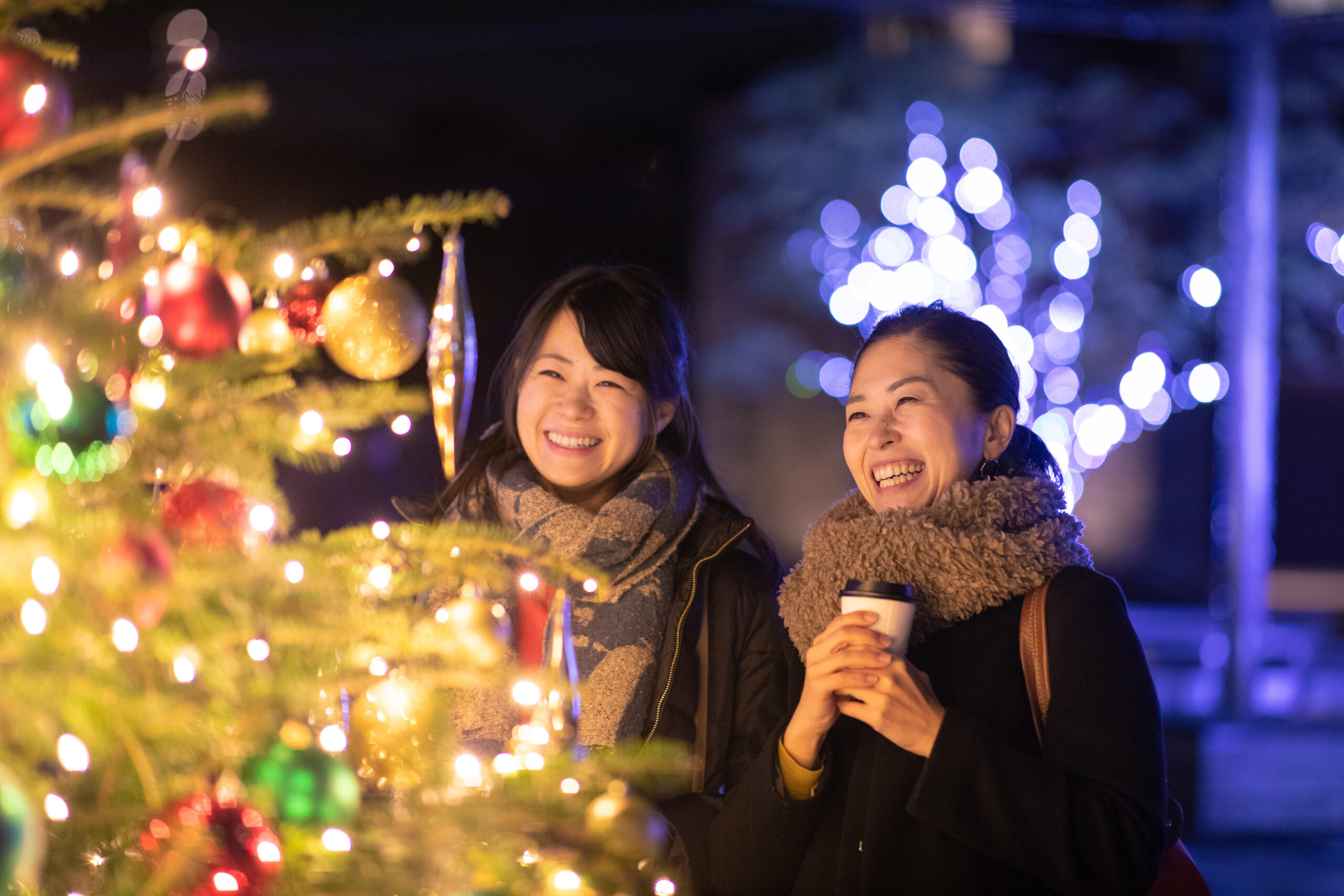 Happy female friends enjoying Christmas lights