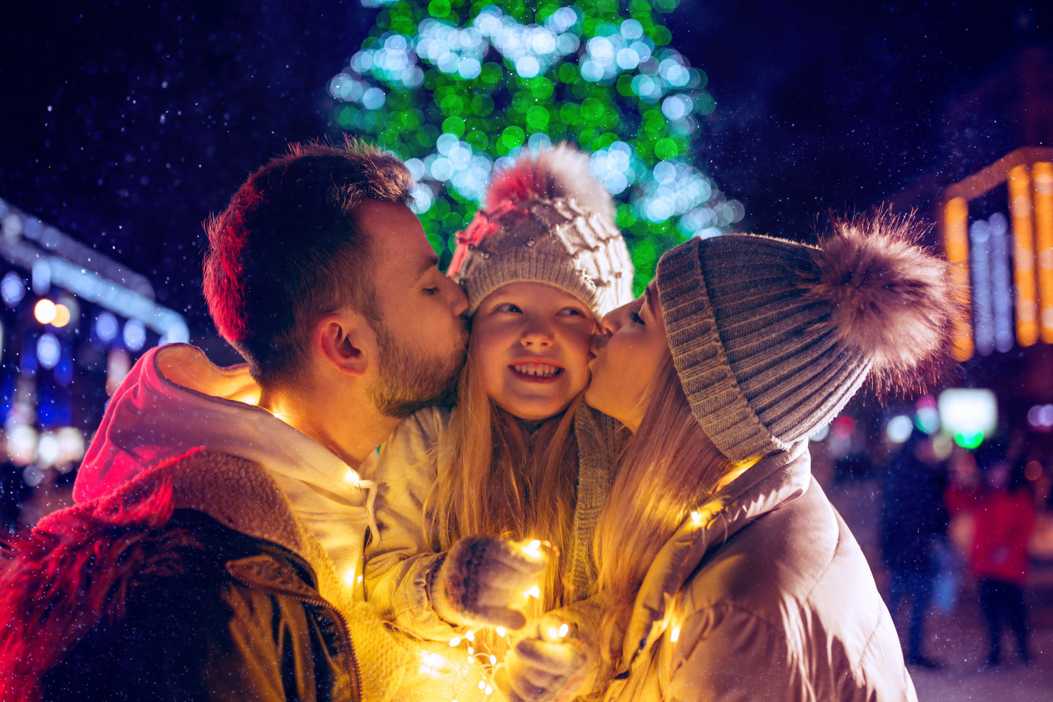 family, christmas, holidays, season and people concept - happy family over city background and snow