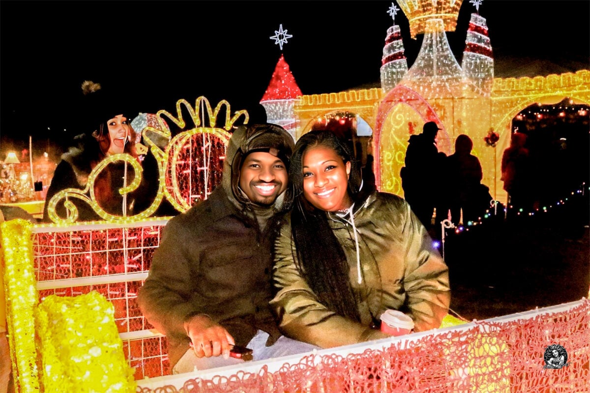 Couple under sparkling white Christmas lights on the half-mile walking trail in Timonium, Maryland