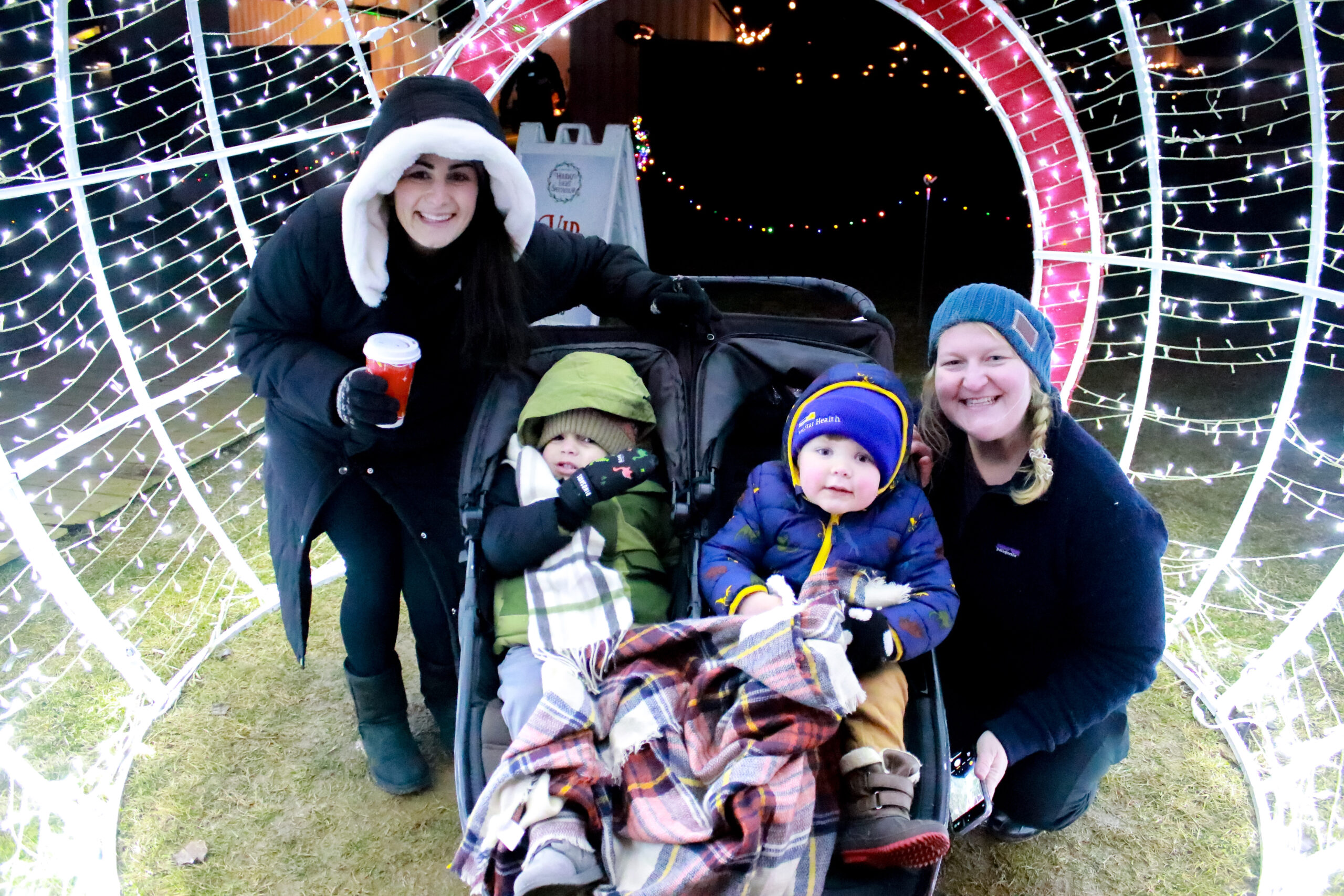 A group walking together beneath the Christmas lights at the Timonium fairgrounds